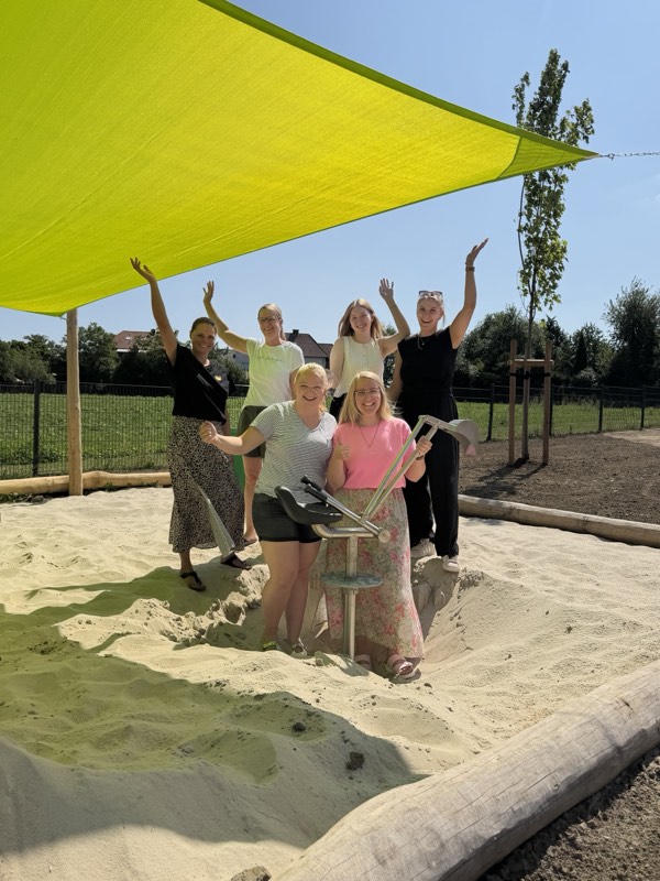 Team der Kita „Grüne Wiese“ bei der Übergabe des neuen Sandbaggers