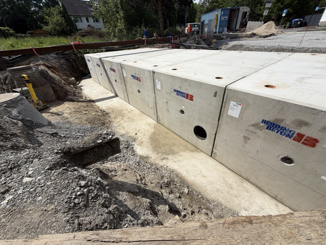 Reihe fertig verlegter Betonfertigteile des Rahmendurchlasses entlang der Baustelle