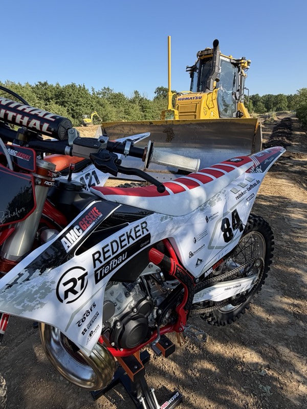 Startaufstellung mehrerer Motocross-Motorräder mit Redeker-Tiefbau-Branding