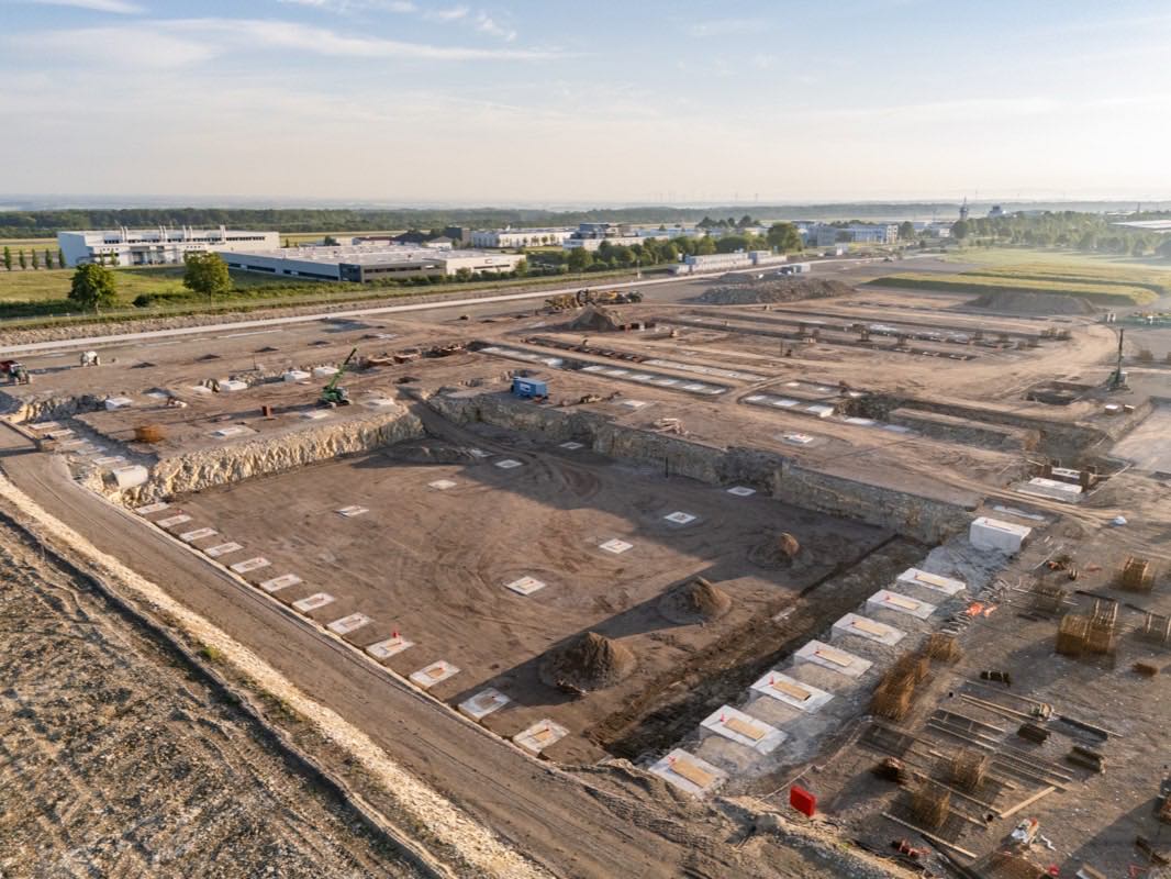 Luftbild einer Gewerbebaustelle mit Fundamenten und Erschließungsflächen