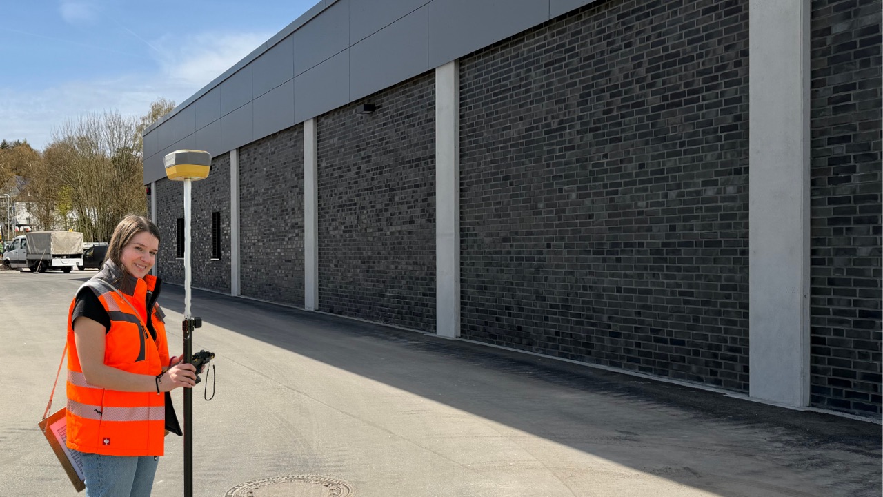 Vermessungstechnikerin der Redeker Tiefbau GmbH mit GPS-Rover auf der Baustelle